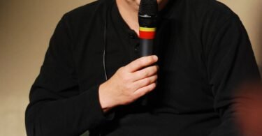 Linus Torvalds speaking into a microphone at a Linux conference