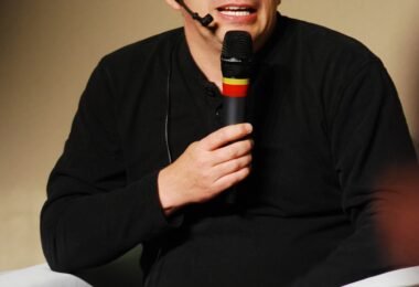 Linus Torvalds speaking into a microphone at a Linux conference