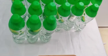 Rows of green plastic bottled water on a shop shelf