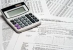 A calculator resting on United States income tax return forms