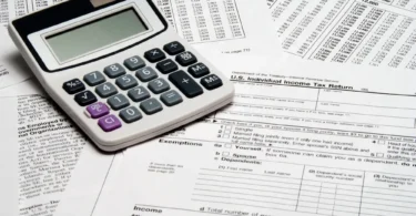 A calculator resting on United States income tax return forms