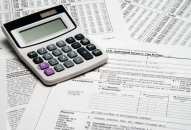 A calculator resting on United States income tax return forms