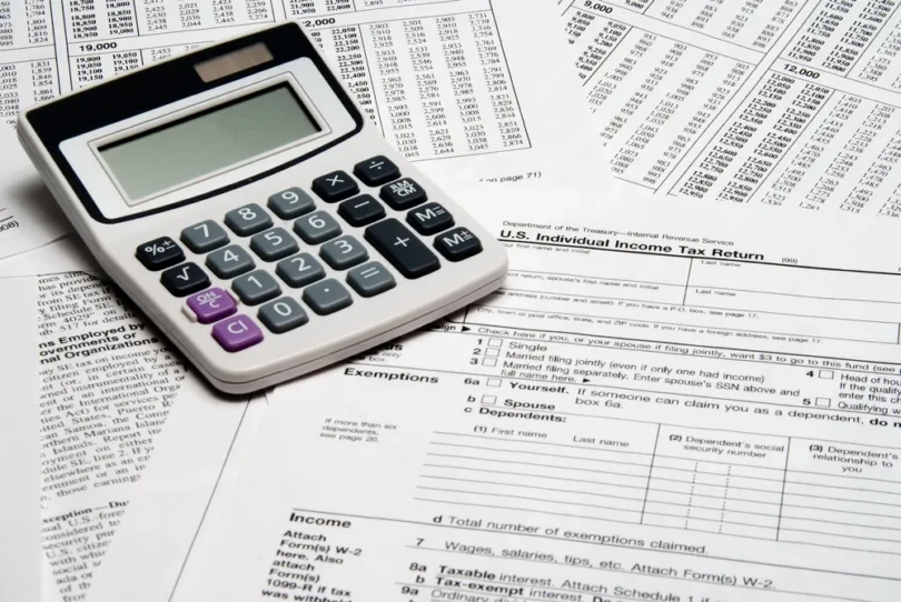 A calculator resting on United States income tax return forms