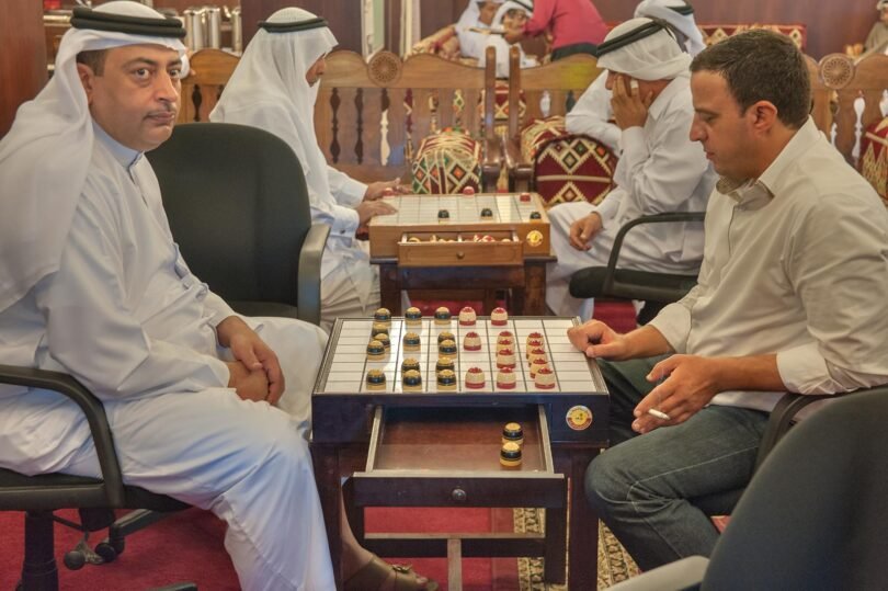 Two men playing a board game at a table